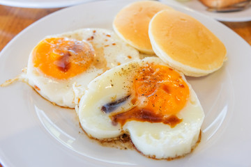 Fried Egg sprinkle with soy sauce and pepper with Pancake serve