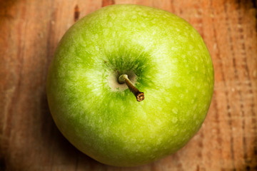 Manzana verde en primer plano sobre un fondo de madera rústico. Vista superior y de cerca