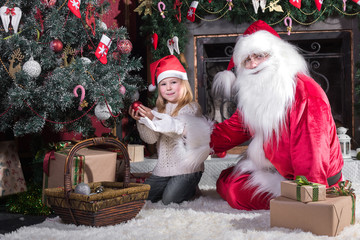 Santa Claus and cute girl getting ready for Christmas.