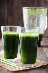 Kale smoothie in glass on wooden background.Copyspace
