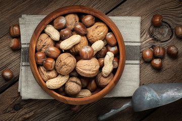 Walnuts, hazelnuts and peanuts in wooden bowl.
