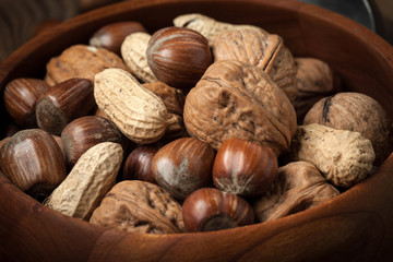 Walnuts, hazelnuts and peanuts in wooden bowl.