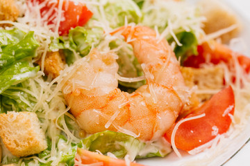 seafood caesar salad with shrimps, salad leaf, parmesan cheese