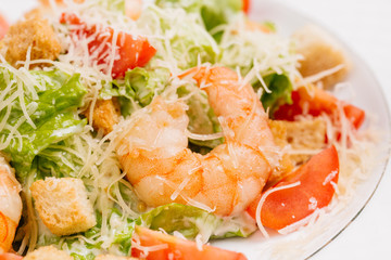 seafood caesar salad with shrimps, salad leaf, parmesan cheese 