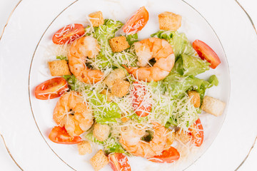 seafood caesar salad with shrimps, salad leaf, parmesan cheese 