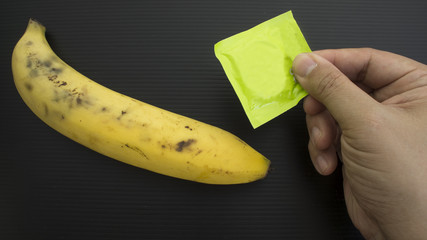Metaphor banana hand hold condom rubber concept