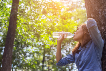 Beautiful young woman drinking water in the morning after finish