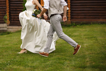 Wedding couple, bride and groom running to place of wedding ceremony at their wedding day