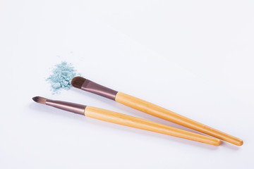 loose eyeshadow and makeup brushes isolated