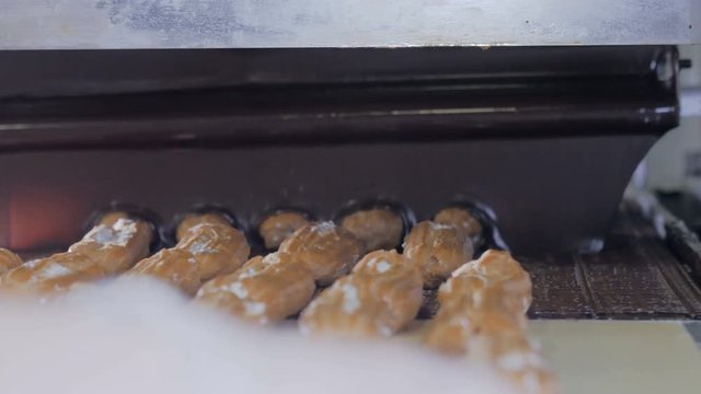 Conveyor line with moving Eclairs. Eclairs, cakes, pastry, dessert production line 4K