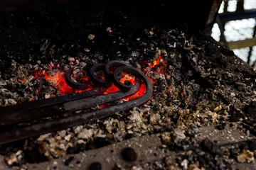 The blacksmith manually forging the molten metal on the anvil