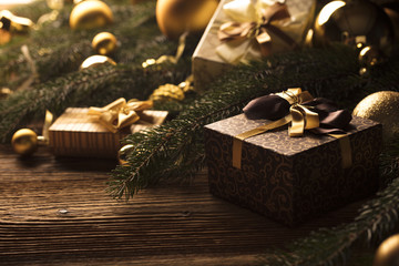 Golden Christmas decoration. Presents in boxes on a wooden background with copy space. Golden baubles. Christmas theme. Golden and brownish aesthetics. Christmas spices.