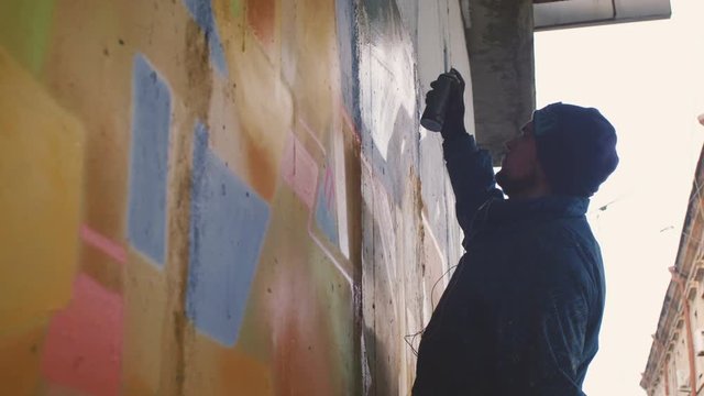 Graffiti artist painting on the wall, exterior