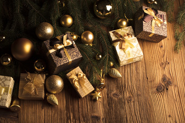 Golden Christmas decoration. Presents in boxes on a wooden background with copy space. Golden baubles. Christmas theme. Golden and brownish aesthetics. Christmas spices.