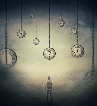 Surrealistic Image With A Man Lost In Time, Standing In A Foggy Street In Front Of Huge Clocks Set To Different Times. Hour Perception And Time Travel Concept.