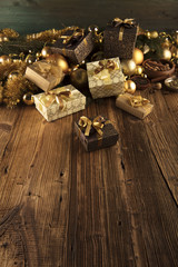 Golden Christmas decoration. Presents in boxes on a wooden background with copy space. Golden baubles. Christmas theme. Golden and brownish aesthetics. Christmas spices.