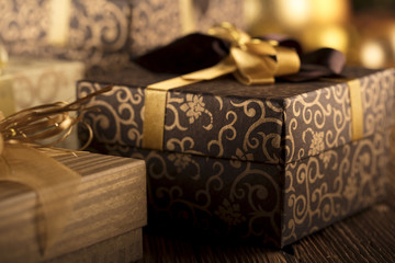 Golden Christmas decoration. Presents in boxes on a wooden background with copy space. Golden baubles. Christmas theme. Golden and brownish aesthetics. Christmas spices.