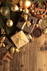 Golden Christmas decoration. Presents in boxes on a wooden background with copy space. Golden baubles. Christmas theme. Golden and brownish aesthetics. Christmas spices.
