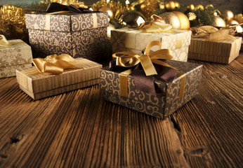 Golden Christmas decoration. Presents in boxes on a wooden background with copy space. Golden baubles. Christmas theme. Golden and brownish aesthetics. Christmas spices.