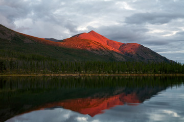 Mountain in the red light of sunset. Lake Labynkyr. Oimyakon Highlands. Yakutia. Russia.