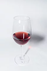 Fotobehang Red vine in a glass on white background © InfinitePhoto