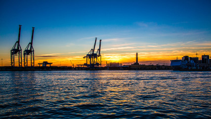 Fototapeta na wymiar sunset at Genoa's port, silhouette of the Lanterna, Italy
