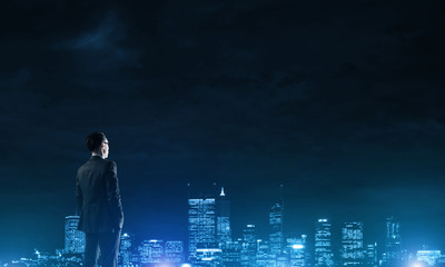 Businessman viewing night glowing city