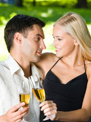 happy couple celebrating with champagne, outdoors