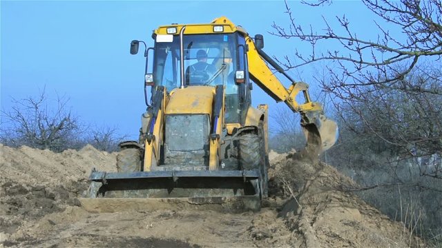 Excavator dripping trench among dead trees. Excavator dripping trench for gas pipeline