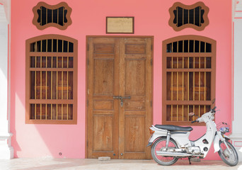 Old pink buildings Sino-Portuguese style with motorcycle in Phuk