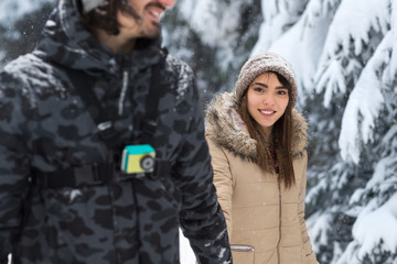 Young Romantic Couple Walking In Snow Forest Outdoor Mix Race man And Woman Holding Hands Winter Pine Woods