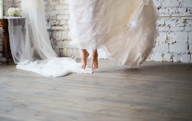 Bride jumping barefoot in rustic white wedding dress. Beautiful wedding gown. Loft style wedding.