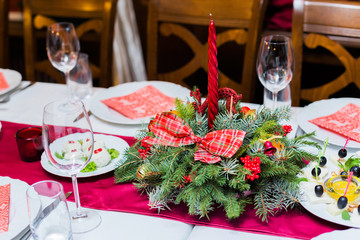 Christmas table place setting with christmas pine branches,ribbon and bow. Xmas and New Year holidays background