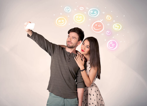 Happy couple taking selfie with smiley