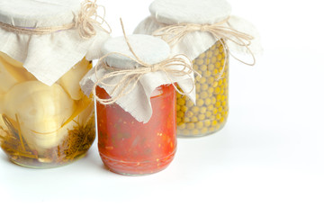Canned vegetables in glass jars isolated on white background