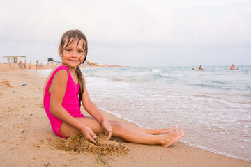 Five-year girl sitting on the beach seaside