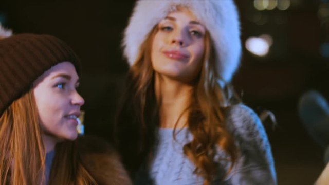 Group of attractive teen girls celebrating something outdoors. Female friends having fun, dancing in the street in winter. 60 FPS slow motion, 4K UHD RAW edited footage