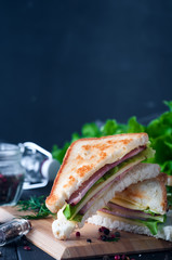 Club sandwich with a salad on a wooden plate
