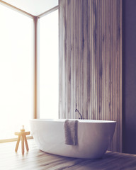 Corner of a bathroom with a tub and a wooden wall, toned