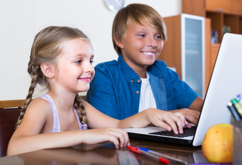 Children playing online on laptop.