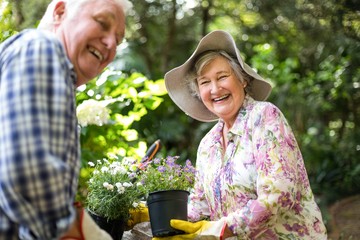 Happy senior couple with flower pots