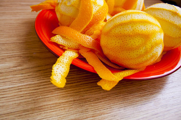 Peeled orange and peel on a red plate