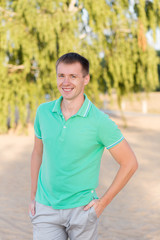 Portrait of beautiful young man on the beach at summer