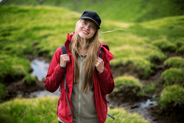 Shot of a young woman looking at the landscape while hiking in the mountains.Outdoor shot of attractive young woman with backpack standing in a mountain stream. Female hiker in creek water.