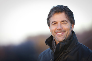 Handsome Mature Happy Man Smiling At The Camera.Outside On a Roof.