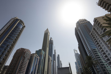 Fototapeta na wymiar Architecture theme and concept. Panorama of tall Skyscrapers in skyline of Dubai against blue sky.