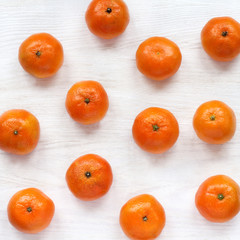 fruit table/ flat layout of orange tangerines lying on a light wooden surface top view 