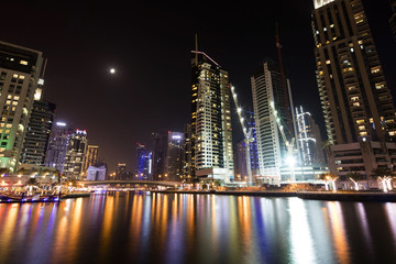 Obraz premium Architecture theme. Dubai marina. Luxurious travel and living, business and finance theme. Luxurious apartments. High value property. Night lights. Illuminated skyline. Big construction site.