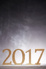 Golden new year in 2017 numbers over gray