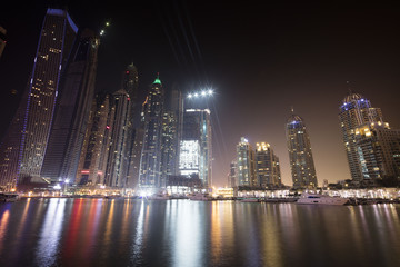 Fototapeta na wymiar Architecture theme. Dubai marina. Luxurious travel and living, business and finance theme. Luxurious apartments. High value property. Night lights. Illuminated skyline. Big construction site.